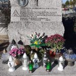 Obelisk Stanisława Miłkowskiego. Na płycie płaskorzeźba twarzy, krzyż, krótka notatka. Na obelisku stoją kwiaty i znicze
