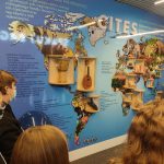 Grupa uczniów podczas zwiedzania lotniska ogląda tablicę z wyszczególnieniem rzeczy, których nie wolno przewozić w samolocie