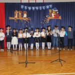 Grupa dzieci stoi na sali gimnastycznej