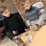 Dwaj chłopcy przy stoliku, liczący pieniądze. Przed nimi na stole banknoty oraz puszka WOŚP