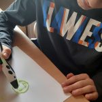 Chłopiec pracuje używając długopisu 3D
