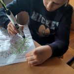 dziewczynka rysuje długopisem 3D kształt liścia.