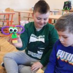 Chłopiec prezentuje konstrukcję z klocków.