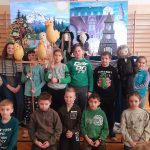 Uczniowie klasy trzeciej stoją na tle sceny z kukiełkami.