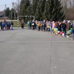 Na bosiku szkolnym zgrmadzeni uczniowie i nauczyciele z emblematami solidarności z Ukrainą