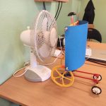 Model urządzenia zbudowany z kolorowych klocków napędzany siłą wiatru. Obok biały wiatrak.