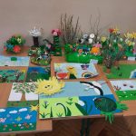 Na stole kolorowe obrazki wiosenne, bukiety kwiatów wiosennych