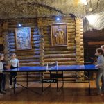 Cztery dziewczynki stojące przy stole do tenisa stołowego.