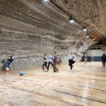 Ośmioro dzieci grających w piłkę nożną na sali gimnastycznej w kopalni.