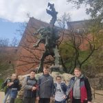 Czterech chłopców pod pomnikiem smoka wawelskiego