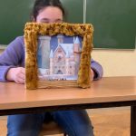 Dziewczynka siedzi w ławce, przed nią stoi teatrzyk kamishibai