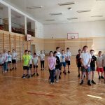 Zawodnicy poszczególnych klas stoją w szeregach na sali gimnastycznej