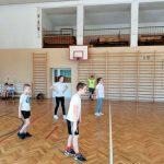 Czworo uczniów podczas meczu czeka na zagrywkę