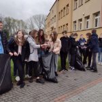 Grupa dzieci po zakończeniu sprzątania do worków wkłada używane rękawiczki