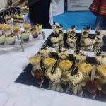 Na stoliku ułożone na tacach desery do poczęstunku dla zwiedzających