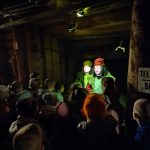 Grupa dzieci patrząca na hologram górników.