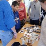 Chłopcy z klasy 6 oglądają elementy gry, m.in. świeczniki, kielich, jarmułki, zdjęcia