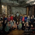 Grupa dzieci ze starym panem w kopalni.