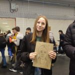 Dziewczynka prezentuje swój portret narysowany przez licealistki
