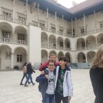 Trzej chłopcy pozują na dziedzińcu Wawelu