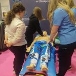 Dwie dziewczynki przyglądają się pierwszej pomocy wykonywanej na fantomie.