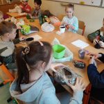 Uczniowie napełniają doniczki ziemią.