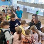 Dzieci częstują się cukierkiem od nauczycielki.