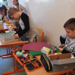 Uczniowie tworzą pomieszczenie domowe z pudełek po różnych produktach.