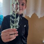 Chłopiec prezentuje wykonane przez siebie pióro