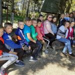 Grupa 16 dzieci siedząca na huśtawce