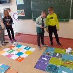 Dwóch chłopców i dwie dziewczynki stoją przed matami i programują prace Photonów