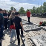 Uczniowie spacerują wzdłuż tablic upamiętniających ofiary Holocaustu