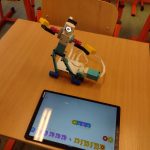 Tańczący ludzik zbudowany z klocków lego oraz tablet z działającym programem.