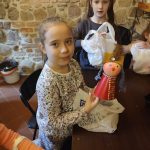 Uczennica prezentuje lalkę szlachciankę.