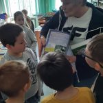Uczniowie oglądają prezentowaną książkę o zwierzętach.
