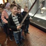 Uczniowie trzymają w rękach miecz i szablę.