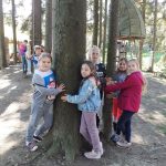 Pieć dziewczynek obejmuje dwa drzewa.