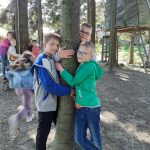 Trzech chłopców przytula się do pnia drzewa