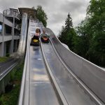 Dwoje uczniów zjeżdża na kocach na ślizgawce