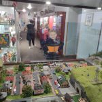 Mały chłopiec patrzy na kolejkę elektryczną ustawioną w gablocie za szybą