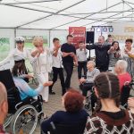 tańczące w kółku osoby (ok. 16 osób). Wśród nich są uczniowie oraz mieszkańcy DPS w Wietrzychowicach.