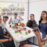 sześć osób – pięć dziewcząt i jednego chłopca – siedzących przy stole.