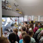 Uczniowie oglądają zgromadzone w gablotach klocki lego