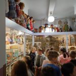 Grupa dzieci ogląda ustawione w gablotach zabawki