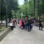 Dzieci idą za nauczycielką w parku