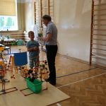 Nauczyciel wręcza chłopcu nagrodę za rozwiązanie zagadki