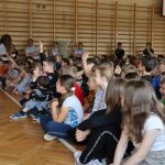 Dzieci siedzące na sali gimnastycznej