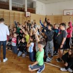 Grupa dzieci z rękami podniesionymi do góry