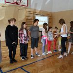 Dwie kobiety wręczają nagrody stojącym dzieciom